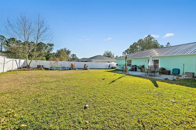 a view of a swimming pool with lawn chairs and plants