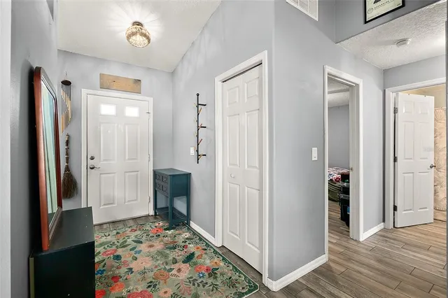 a view of a hallway with wooden floor and a bathroom