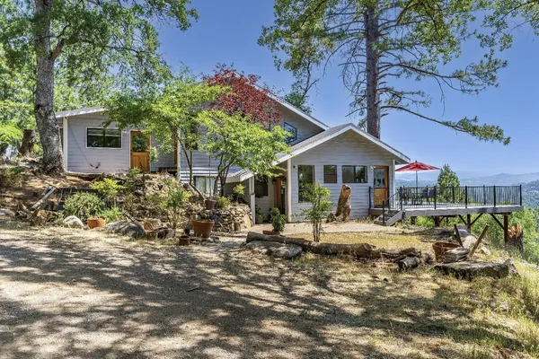 a front view of house with yard and trees in the background