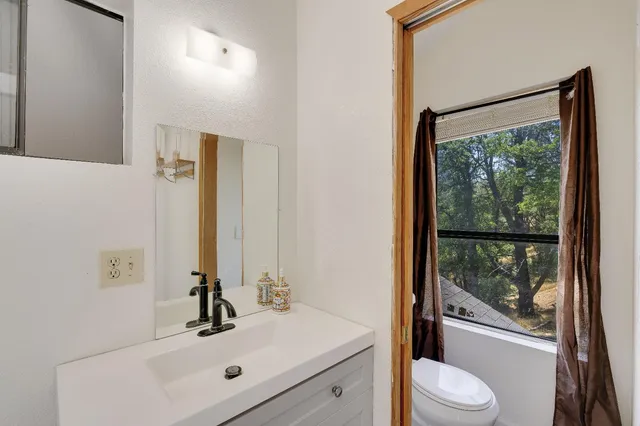 a bathroom with a granite countertop sink and a mirror