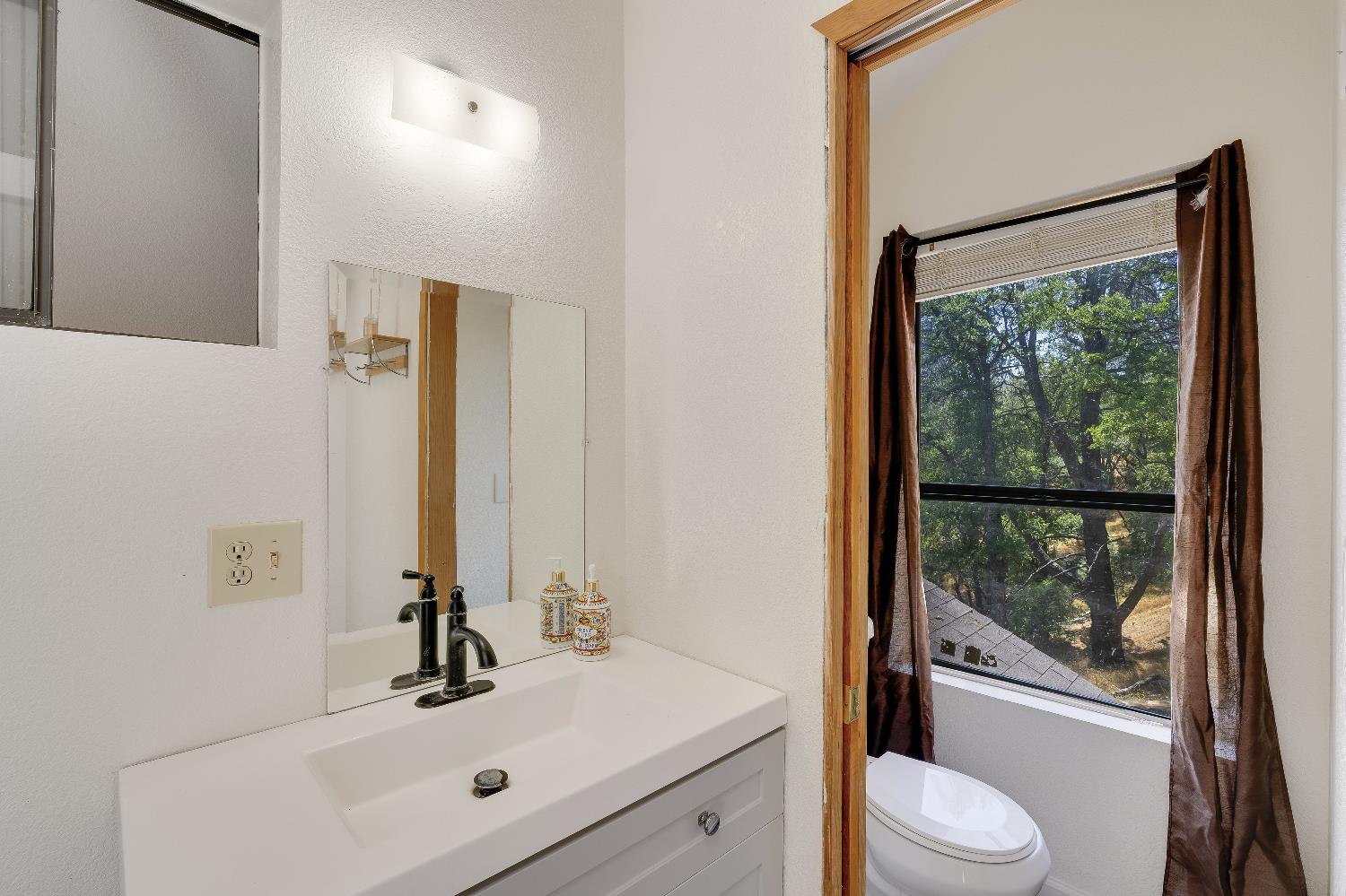 2261 Sand Ridge Road El Dorado, CA 95623 - Photo 26 of 61 a bathroom with a sink mirror vanity and toilet