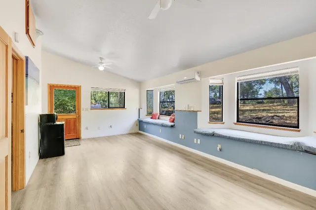 a view of house with outdoor seating area and trees