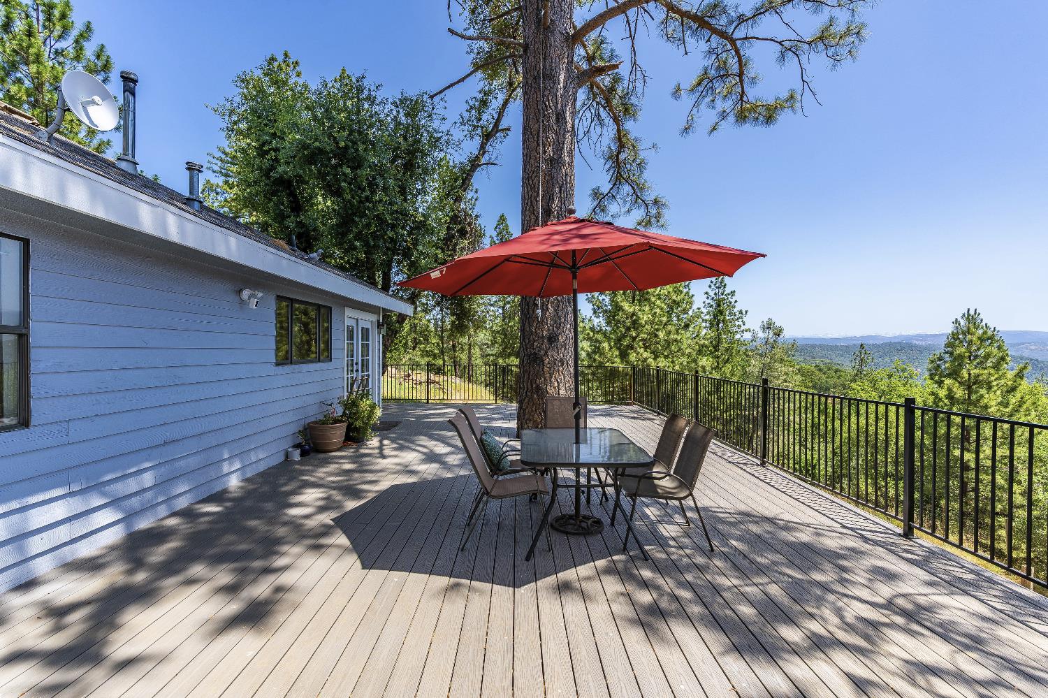 2261 Sand Ridge Road El Dorado, CA 95623 - Photo 47 of 61 a view of a roof deck with table and chairs under an umbrella with wooden floor and fence