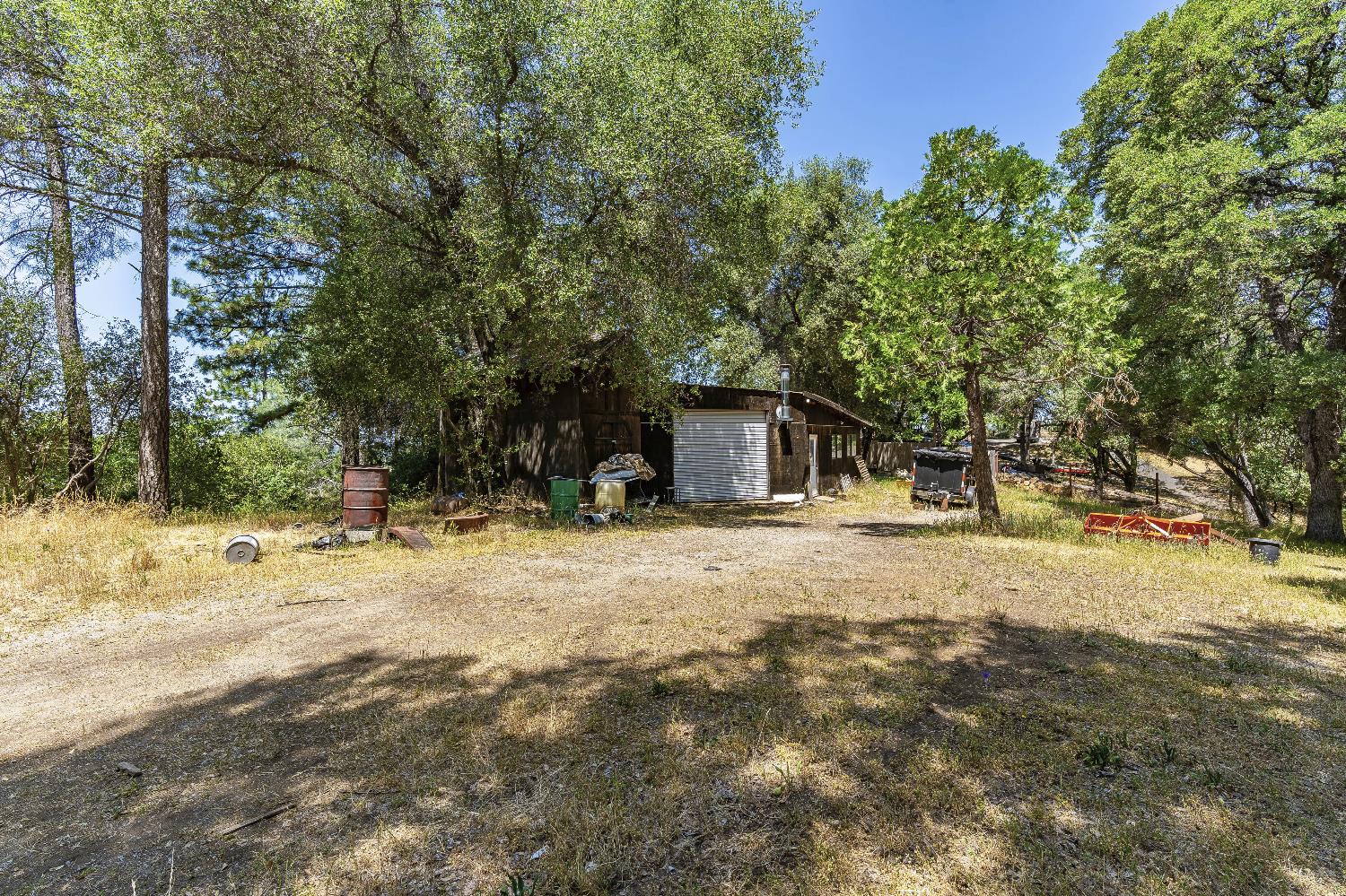 2261 Sand Ridge Road El Dorado, CA 95623 - Photo 49 of 61 a backyard of a house with table and chairs under an umbrella