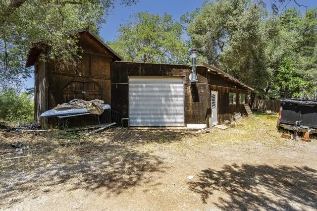 a view of a house with backyard and trees