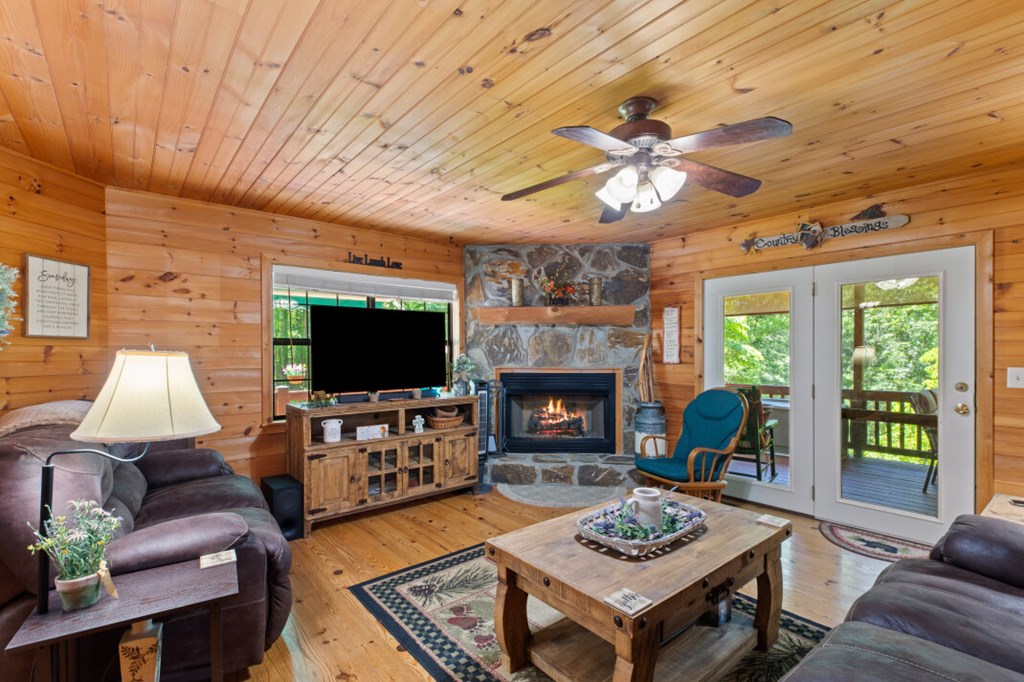 66 Fortenberry Road Young Harris, GA 30582 - Photo 12 of 55 a living room with furniture a fireplace a flat screen tv and a large window