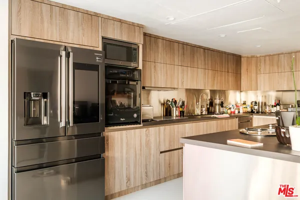 a kitchen with stainless steel appliances a refrigerator and a stove top oven