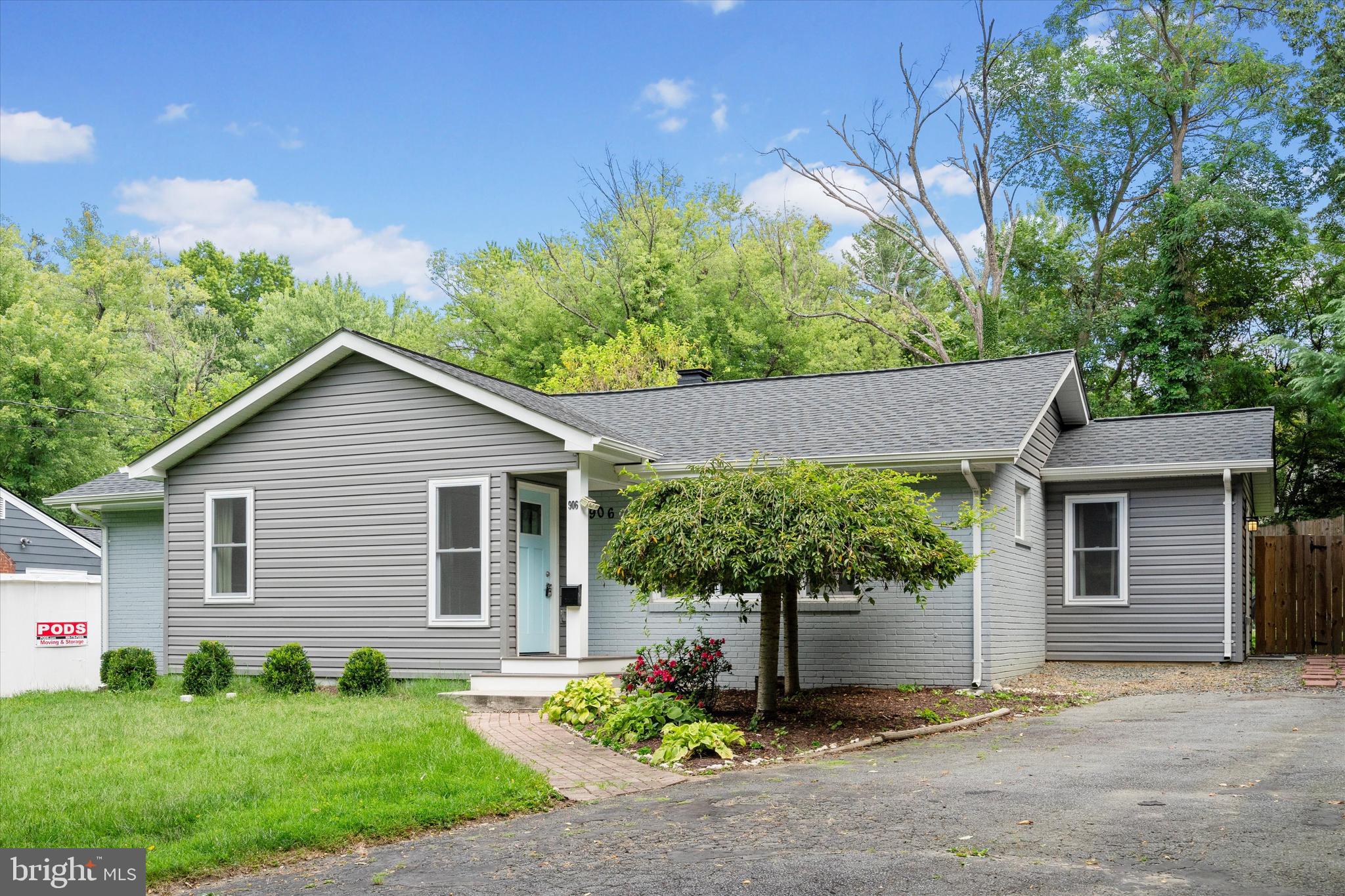 a view of a house with a yard and potted plants