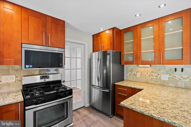 a kitchen with stainless steel appliances granite countertop a stove refrigerator and microwave