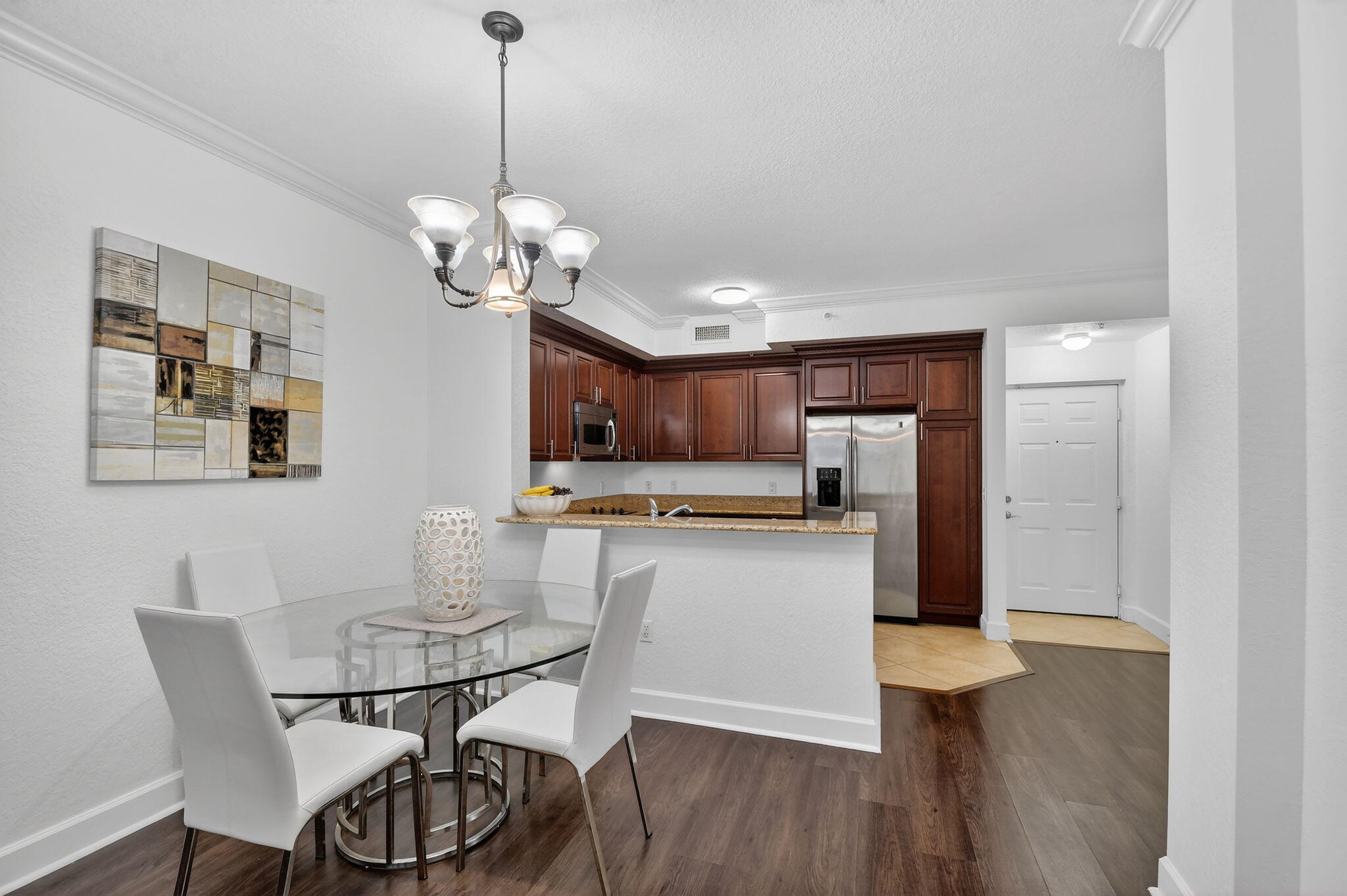 3110 Renaissance Way, Unit 110 Boynton Beach, FL 33426 - Photo 11 of 45 a view of a dining room with furniture wooden floor and chandelier