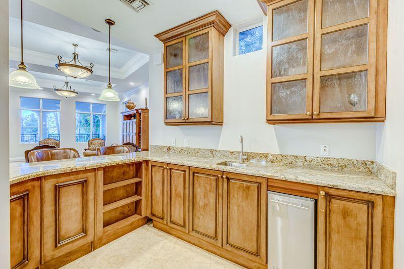 3110 Renaissance Way, Unit 110 Boynton Beach, FL 33426 - Photo 29 of 45 a kitchen with stainless steel appliances granite countertop a sink and dishwasher cabinets with wooden floor