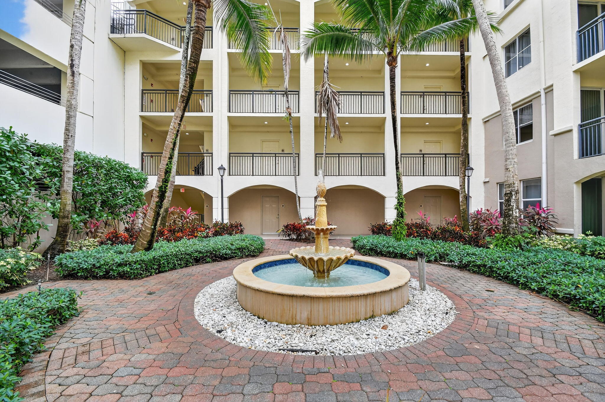 3110 Renaissance Way, Unit 110 Boynton Beach, FL 33426 - Photo 7 of 45 a view of a fountain in front of a brick building
