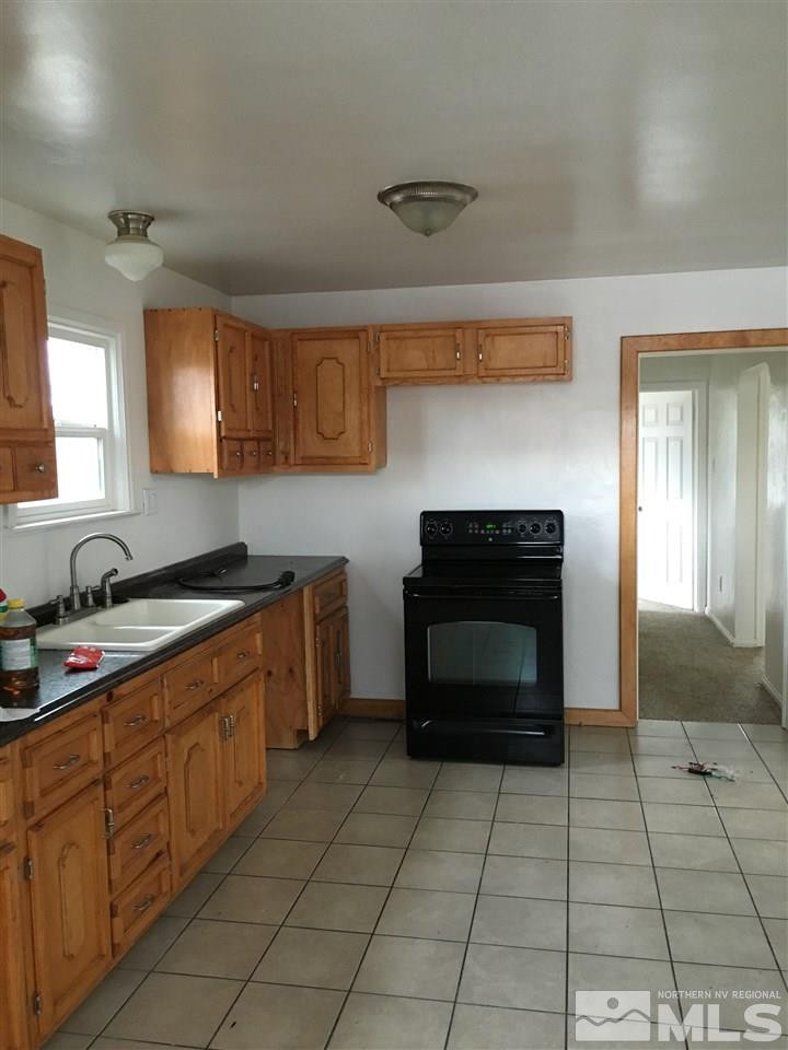 1335 Oliver Avenue Reno, NV 89512 - Photo 6 of 11 a kitchen with granite countertop a stove top oven and cabinets