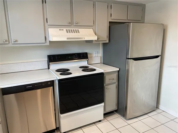 a kitchen with stainless steel appliances a refrigerator sink and cabinets