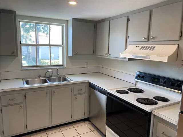 a kitchen with a sink a stove and cabinets