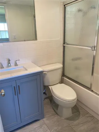 a white toilet sitting next to a bathroom sink