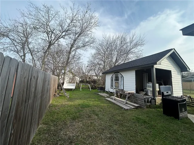 a backyard of a house with table and chairs