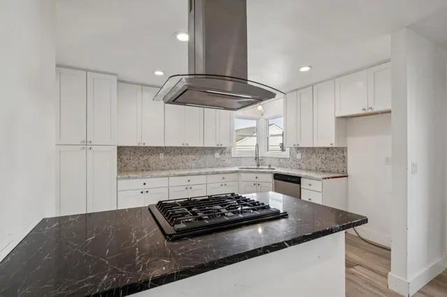a kitchen with granite countertop a stove and a sink
