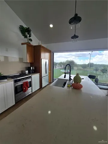 a kitchen with stainless steel appliances a sink a stove and a refrigerator