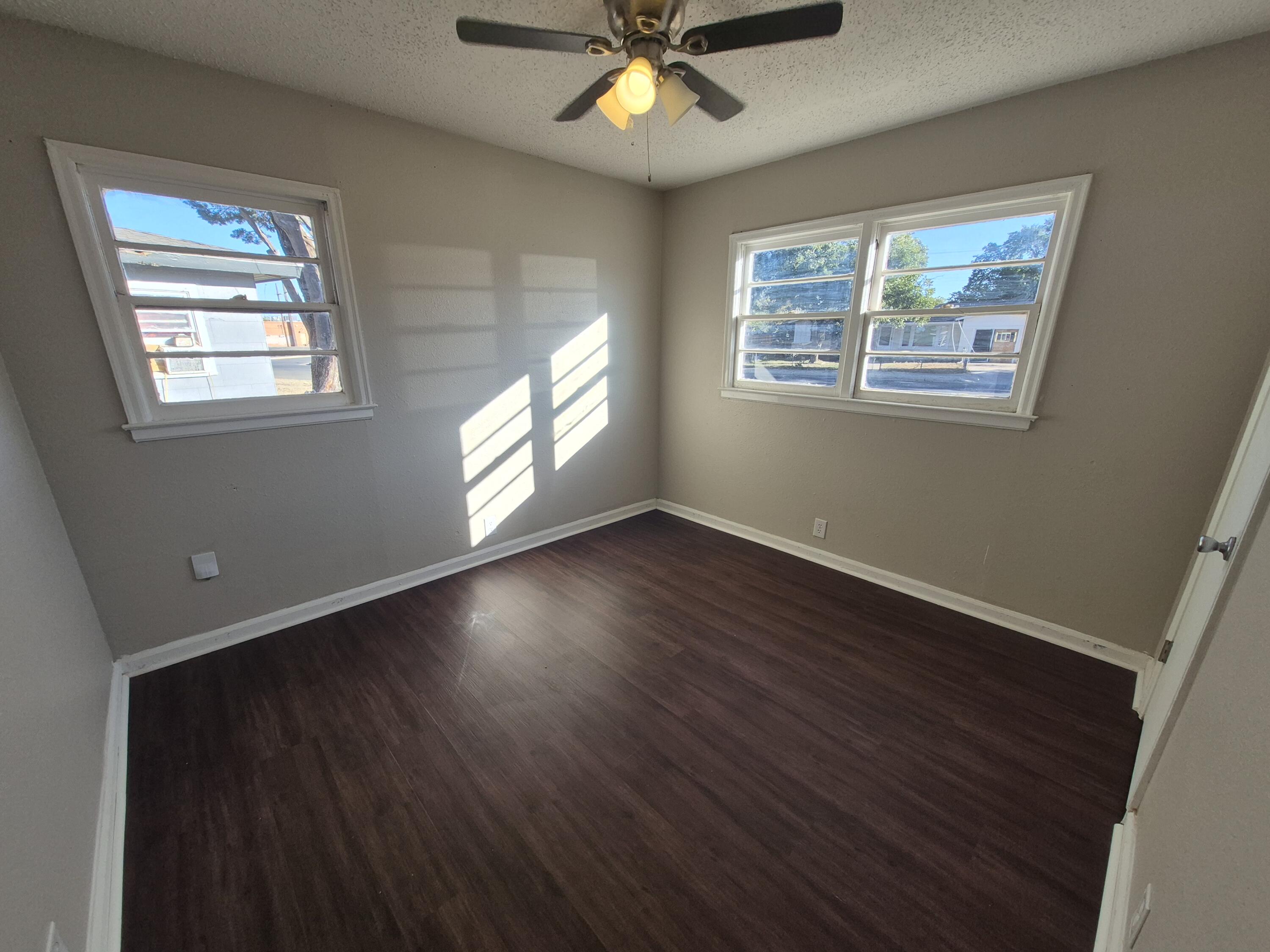 1714 42nd Street Lubbock, TX 79412 - Photo 14 of 16 a view of an empty room with wooden floor and a window