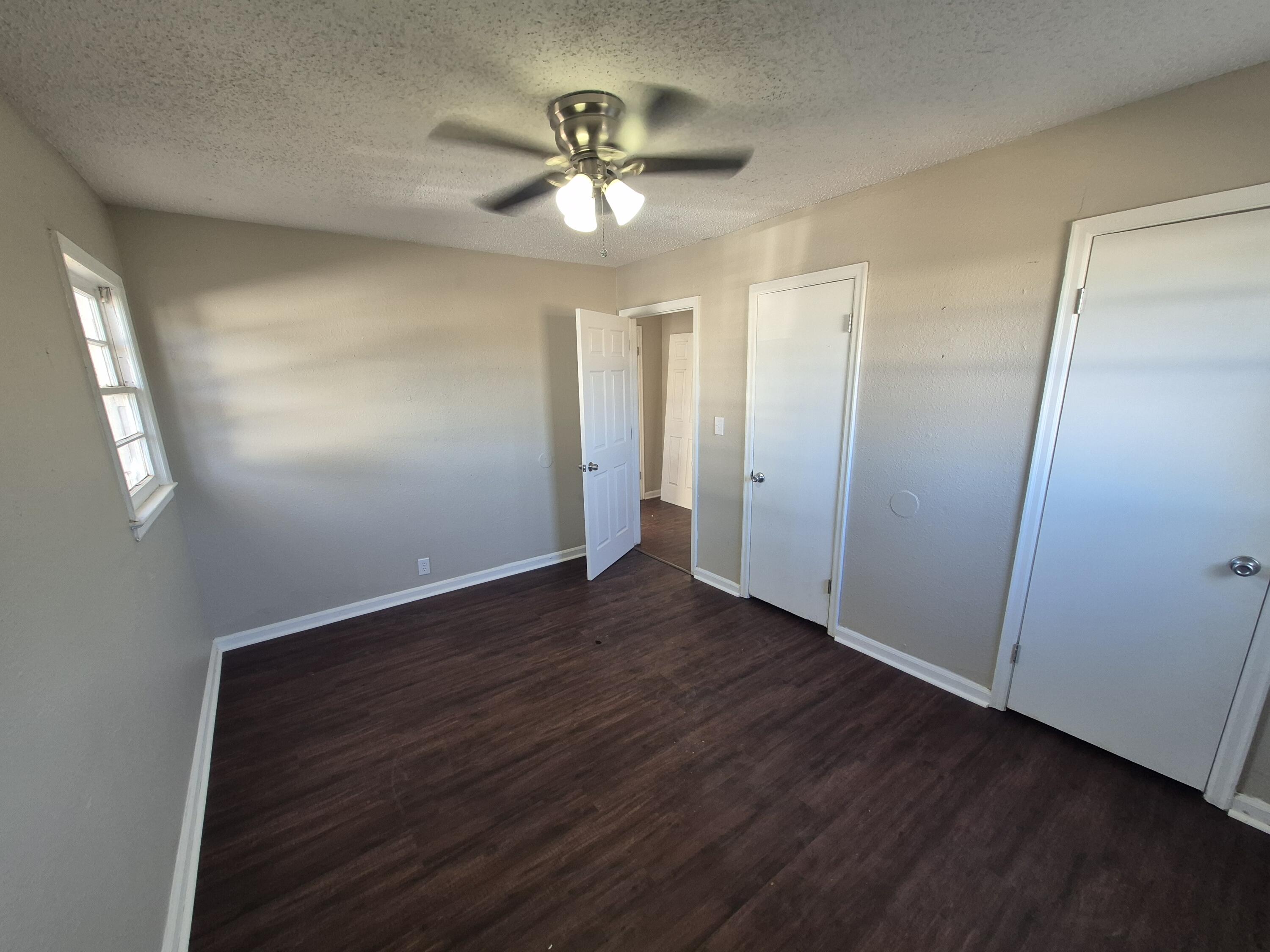 1714 42nd Street Lubbock, TX 79412 - Photo 16 of 16 an empty room with wooden floor fan and windows
