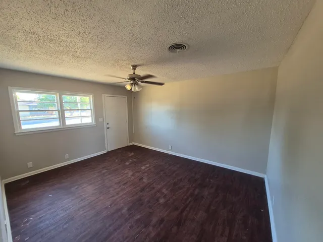 wooden floor in an empty room with a window
