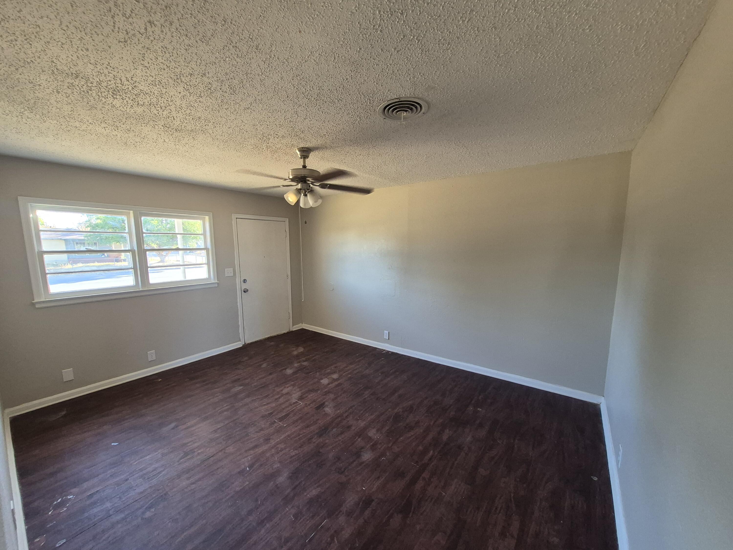 1714 42nd Street Lubbock, TX 79412 - Photo 3 of 16 wooden floor in an empty room with a window
