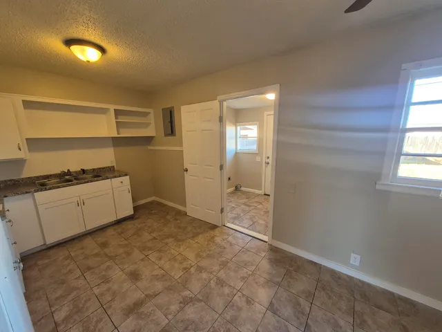 a view of a kitchen with a sink refrigerator and window