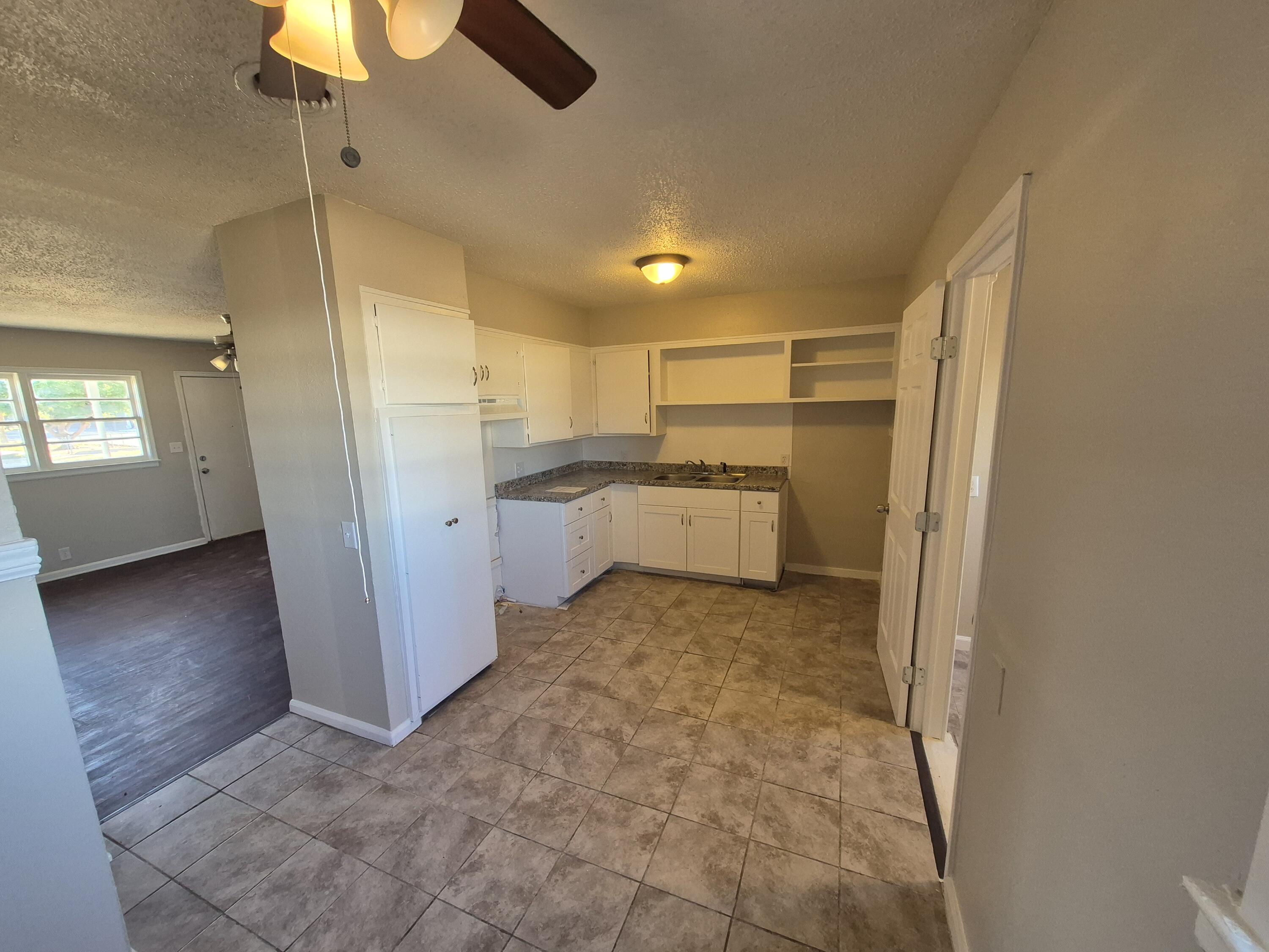1714 42nd Street Lubbock, TX 79412 - Photo 5 of 16 a view of a kitchen with a sink refrigerator and window