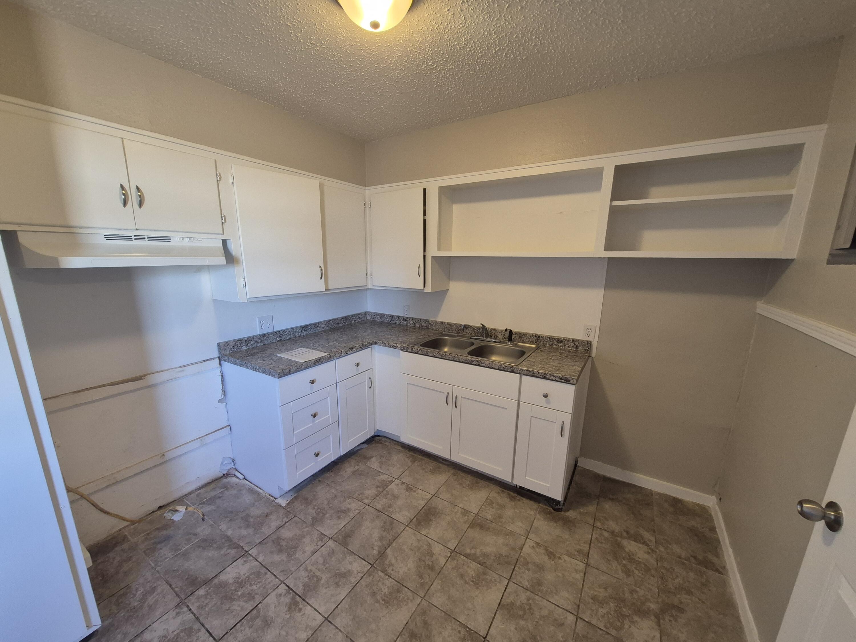 1714 42nd Street Lubbock, TX 79412 - Photo 6 of 16 a kitchen with granite countertop white cabinets and white appliances