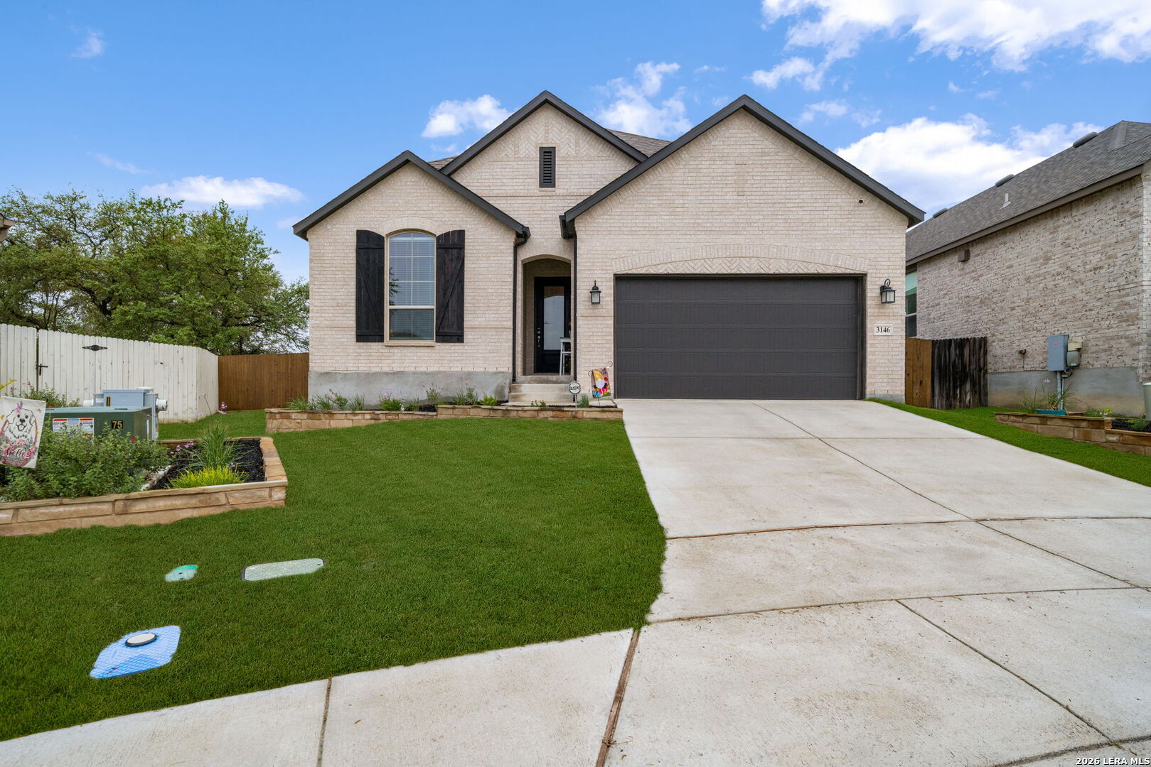 a front view of a house with a garden and yard