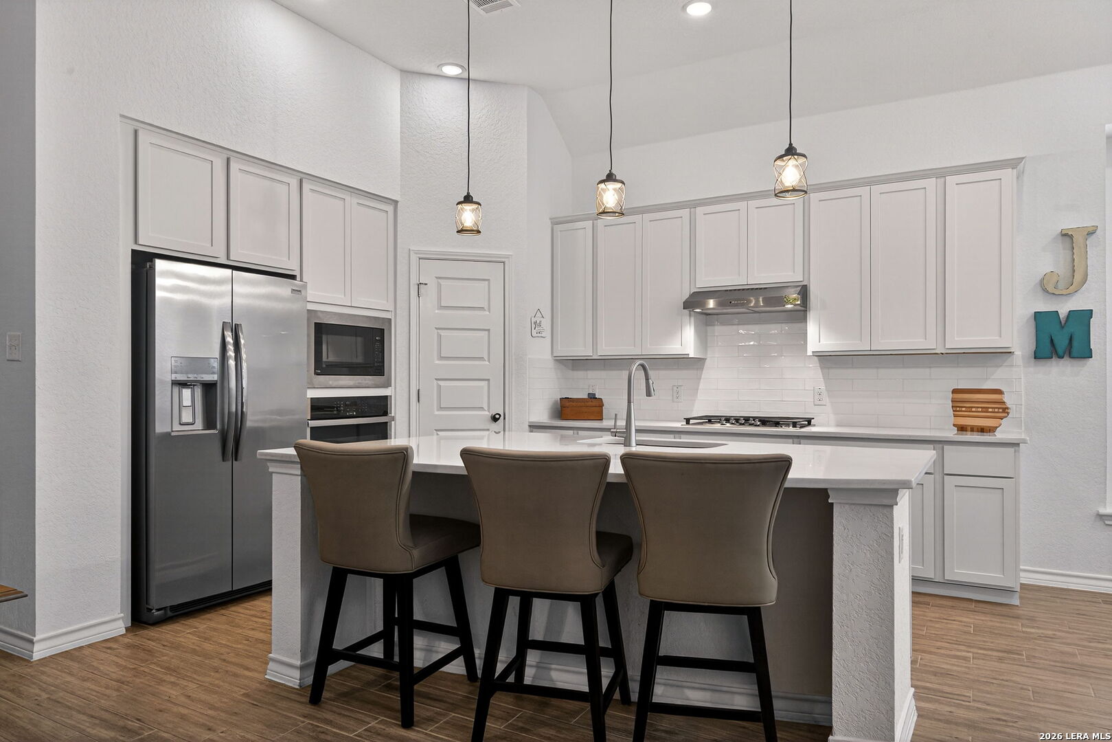 3146 Stokesay Bulverde, TX 78163 - Photo 12 of 30 a kitchen with stainless steel appliances a white table chairs refrigerator and microwave