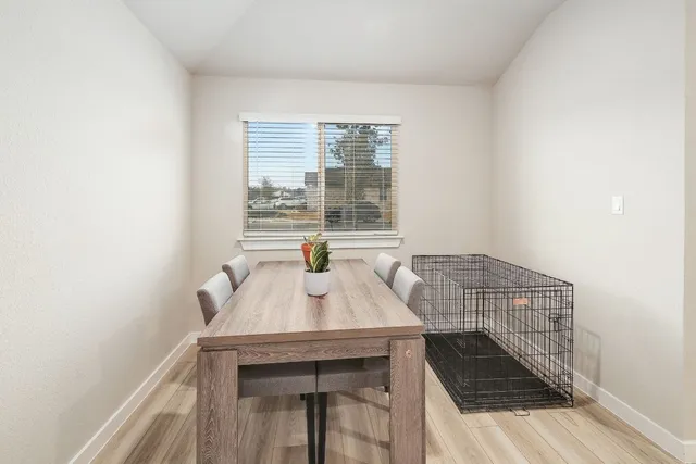 a kitchen with stainless steel appliances granite countertop a stove top oven a sink dishwasher and white cabinets with wooden floor