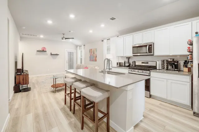 a kitchen with stainless steel appliances kitchen island granite countertop a sink and cabinets