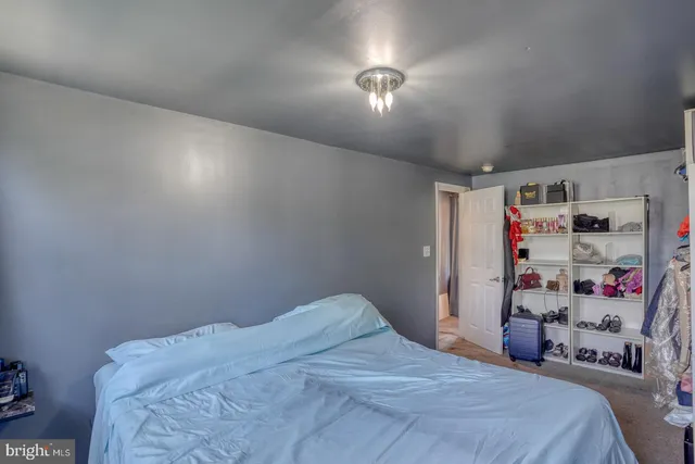 a bedroom with a bed a mirror on dresser and a flat screen tv