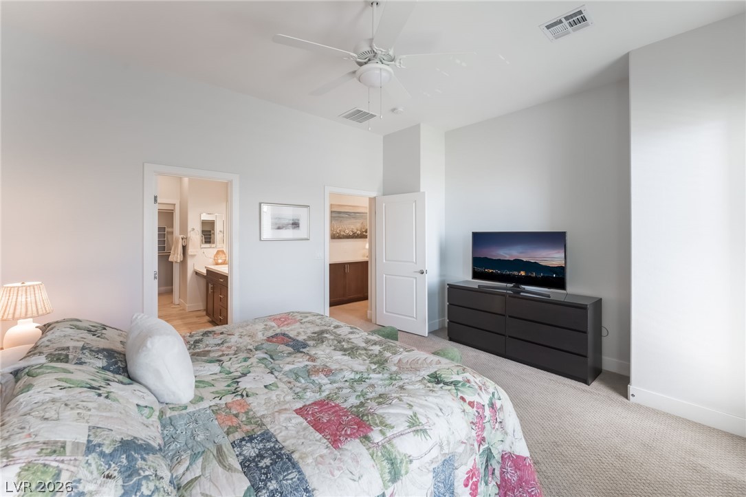 6432 Spring Jog Street Las Vegas, NV 89166 - Photo 19 of 61 Relax in a comfortable bedroom featuring a ceiling fan, plush carpet, and convenient en-suite bathroom access.