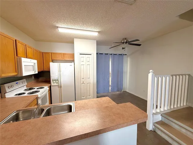 a kitchen with sink refrigerator and window