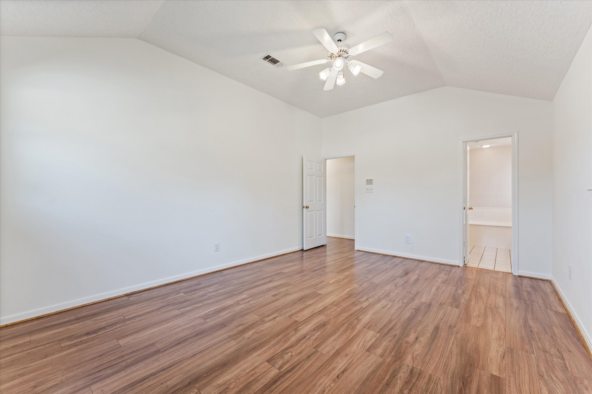 215 Deep Dale Lane Conroe, TX 77304 - Photo 20 of 34 The Primary bedroom features coffered ceilings, fan, & timeless wood plank flooring.