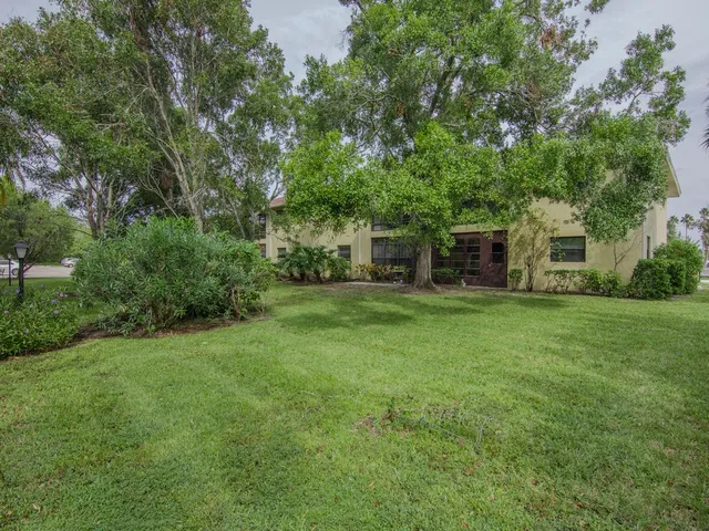a view of a house with backyard and trees