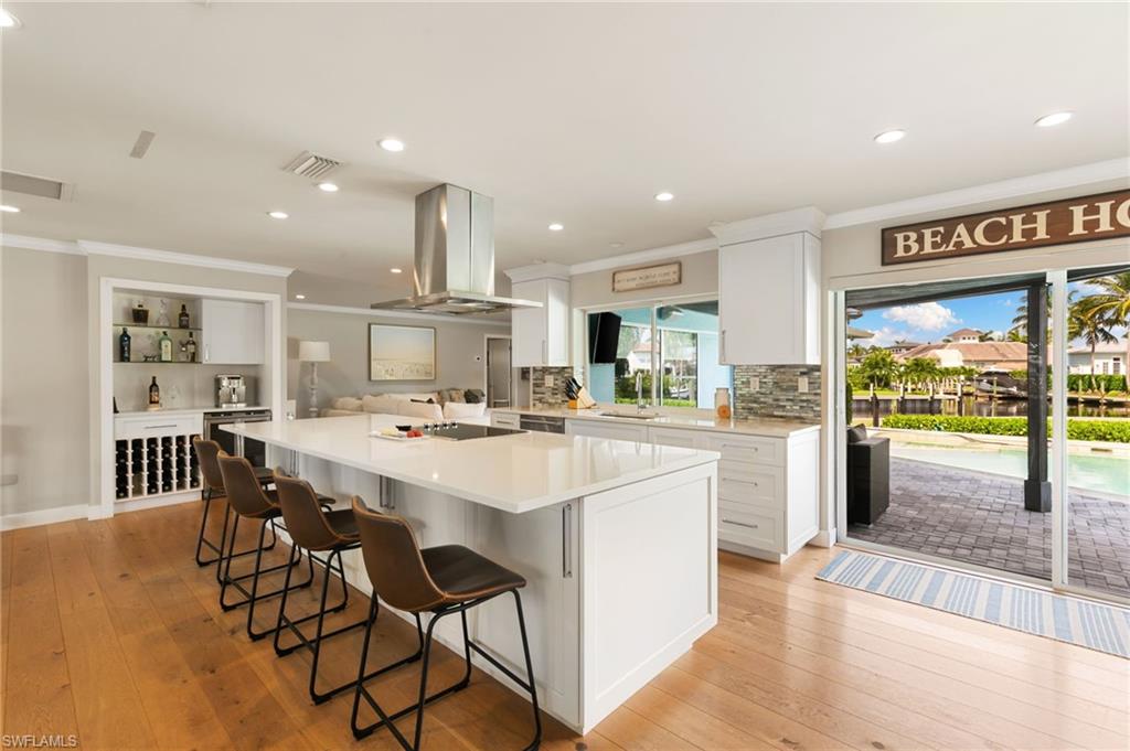 2140 Shad Court Naples, FL 34102 - Photo 28 of 44 a kitchen with a dining table chairs and white appliances