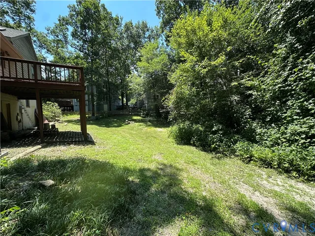 a view of backyard with deck and garden