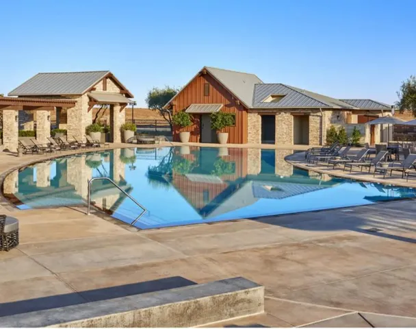 a view of a house with pool and sitting area