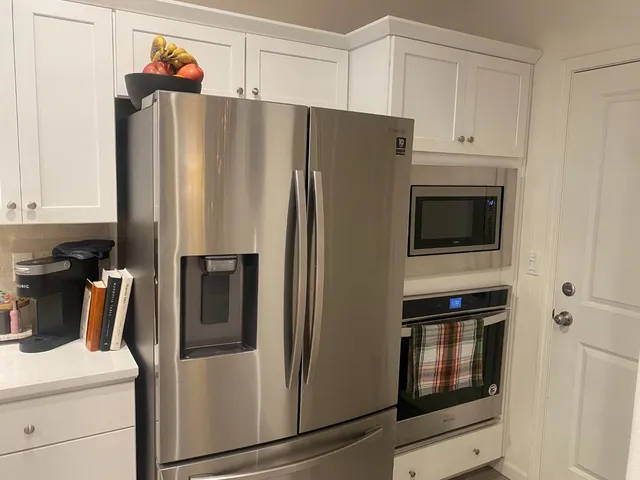 a metallic refrigerator freezer sitting in a kitchen