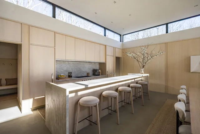 a large white kitchen with a large window and stainless steel appliances