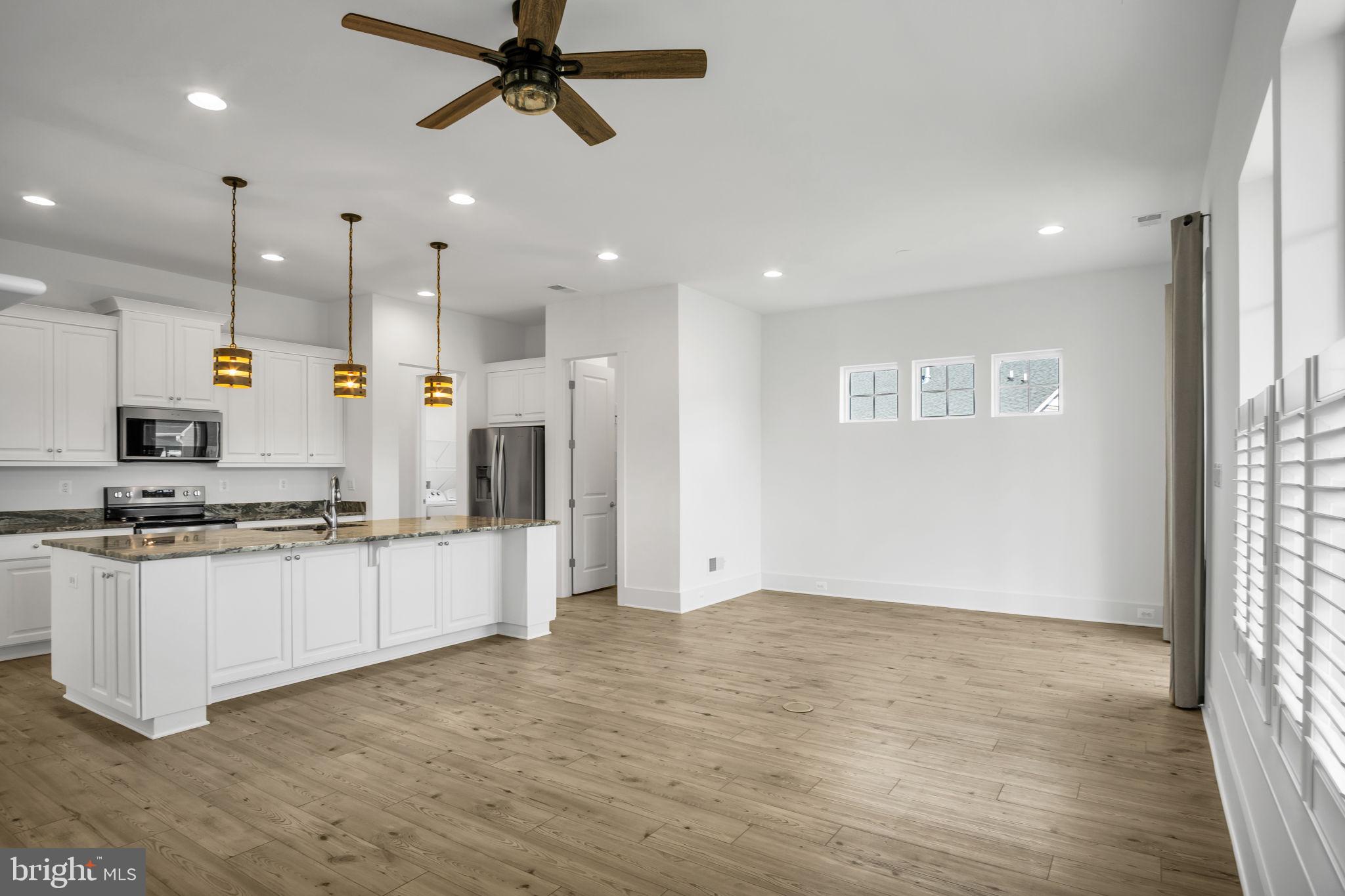 23 Highland View Lane Gettysburg, PA 17325 - Photo 14 of 87 a kitchen with stainless steel appliances granite countertop a stove a refrigerator a sink a microwave oven with white cabinets and wooden floor