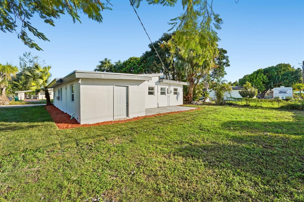 27100 Southwest 144th Avenue Homestead, FL 33032 - Photo 22 of 24 a backyard of a house with plants and trees