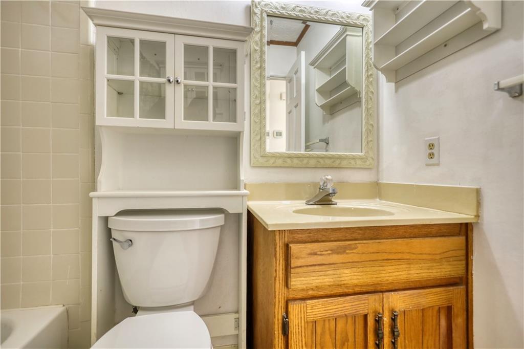 5113 Brownlee Road Southwest Lilburn, GA 30047 - Photo 19 of 48 a bathroom with a toilet sink and mirror