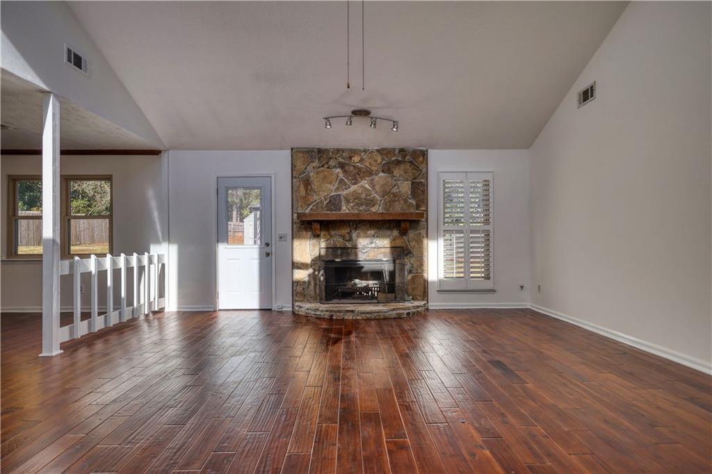 5113 Brownlee Road Southwest Lilburn, GA 30047 - Photo 2 of 48 an empty room with wooden floor fireplace and windows