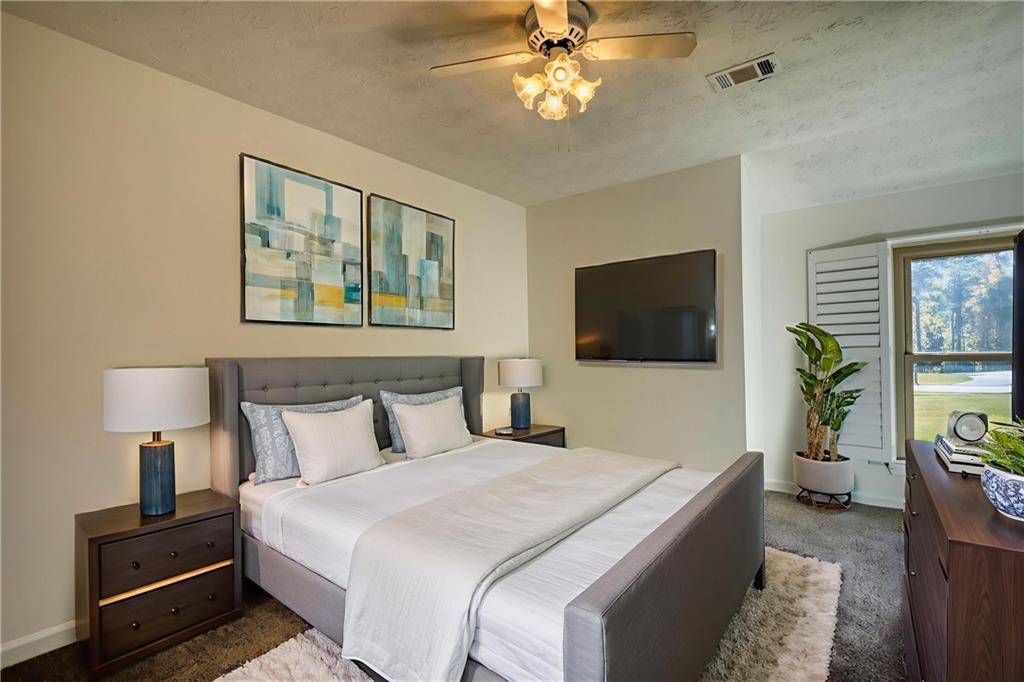 5113 Brownlee Road Southwest Lilburn, GA 30047 - Photo 22 of 48 a bedroom with a bed and a flat screen tv