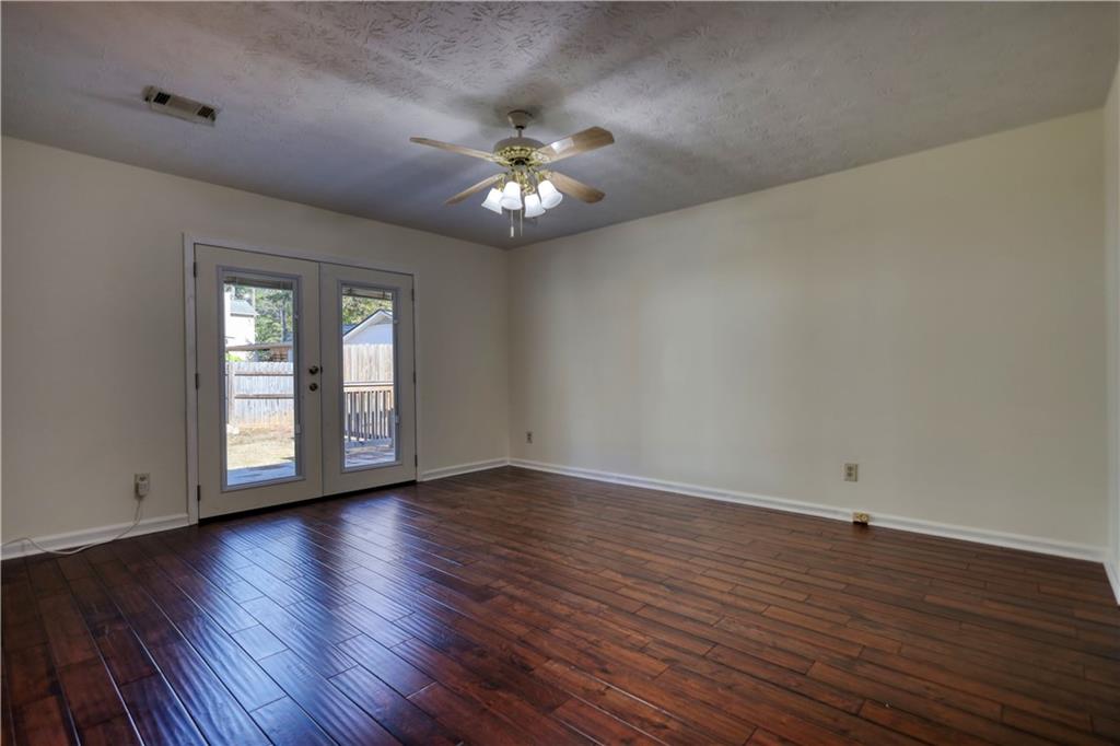 5113 Brownlee Road Southwest Lilburn, GA 30047 - Photo 23 of 48 a view of an empty room with wooden floor and a window